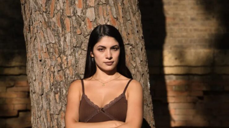 donna appoggiata ad un tronco