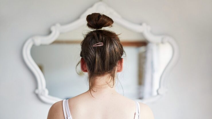 ragazza allo specchio di spalle