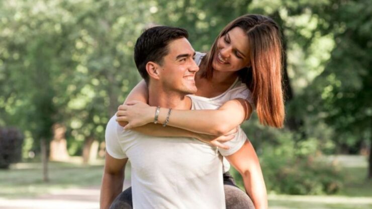 uomo che tiene una donna sulle spalle