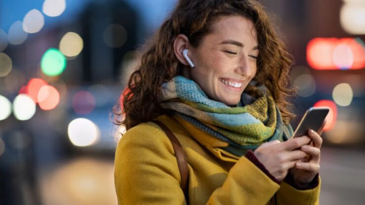 ragazza che sorride guardando il cellulare